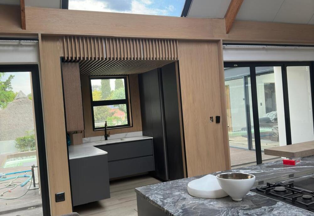 Custom kitchen and living wing during finishing, new build